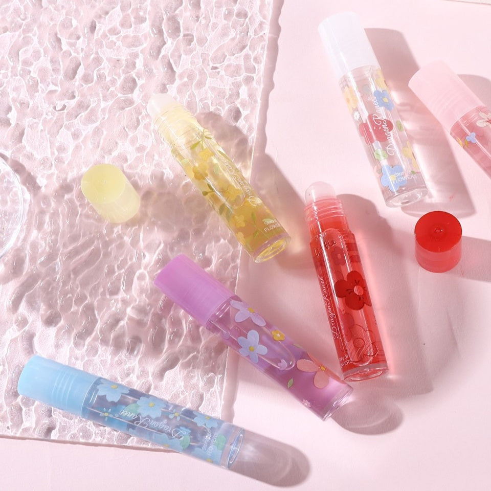 des huiles pour les lèvres aux doux doux parfums de fleurs. Les tubes sont colorés et en verre avec un design de fleurs.