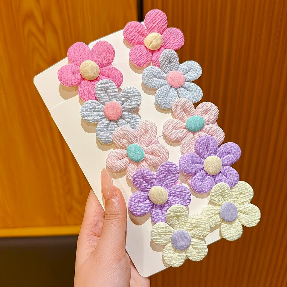 de jolies barrettes à cheveux en forme de petites fleurs rondes colorées en tissu.