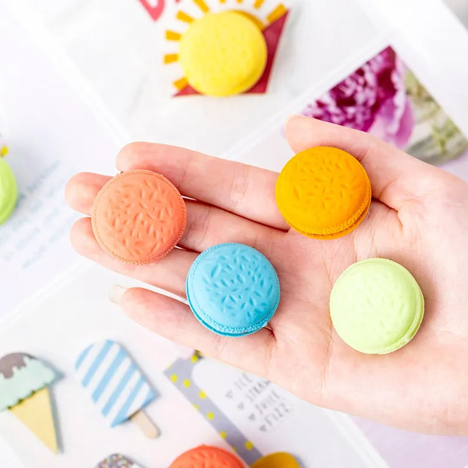 un lot de gommes en forme de macarons gourmands colorés : bleu, rose, vert, jaune, orange avec un coeur chocolat. Effet trompe l'oeil réaliste et mignon.