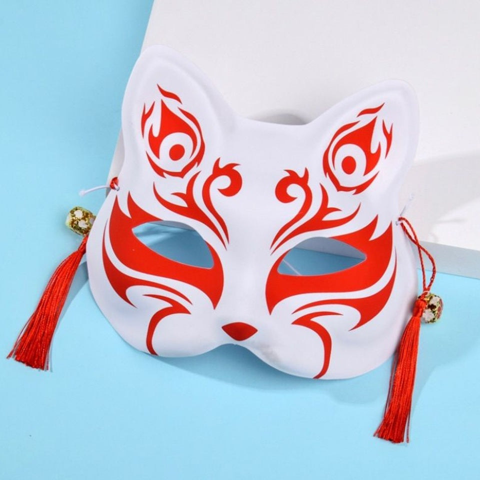 un masque kitsune rouge stylisé, avec des pompons et clochettes. En palstique souple, il est parfait pour le cosplay et les soirées déguisées. Il est très beau même en décoration