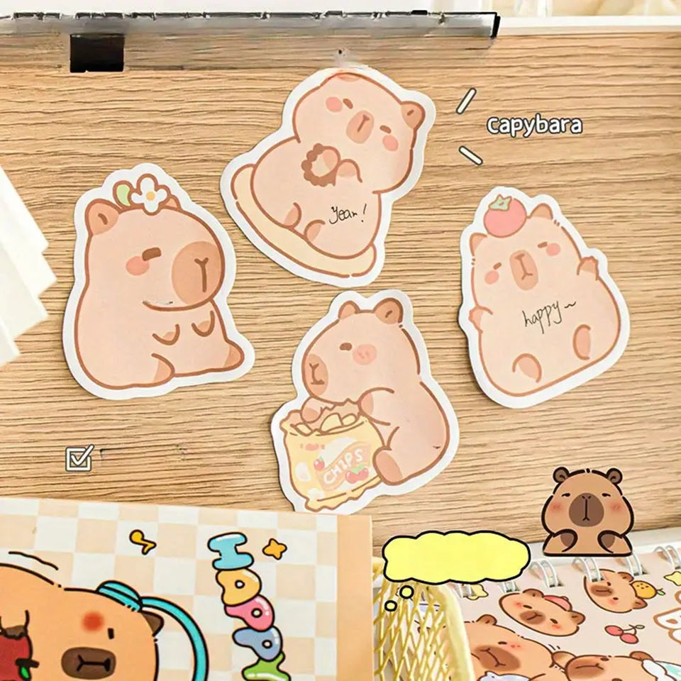 des mémos adhésifs inspirés des capybara. Avec leur expression calme et tendre, ils sont adorables. Dans des positions amusantes et mignonnes, ils sont parfaits pour laisser des messages.