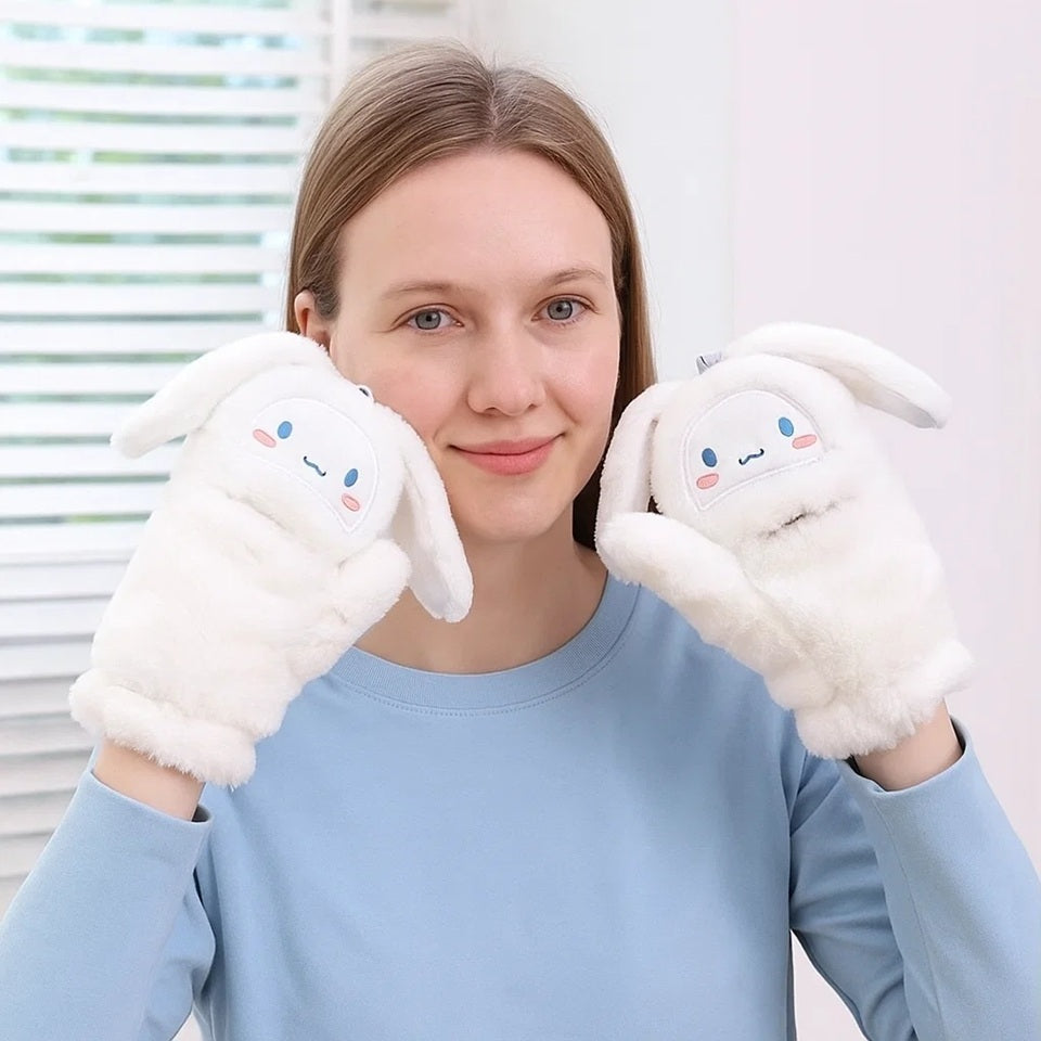 une paire de moufles blanches et toute douces représentant Cinnamoroll. Elles ont de longues oreilles blanches et on peut rabattre le haut des moufles et l'accrocher avec un bouton. Pratiques pour effectuer des tâches sans les enlever.