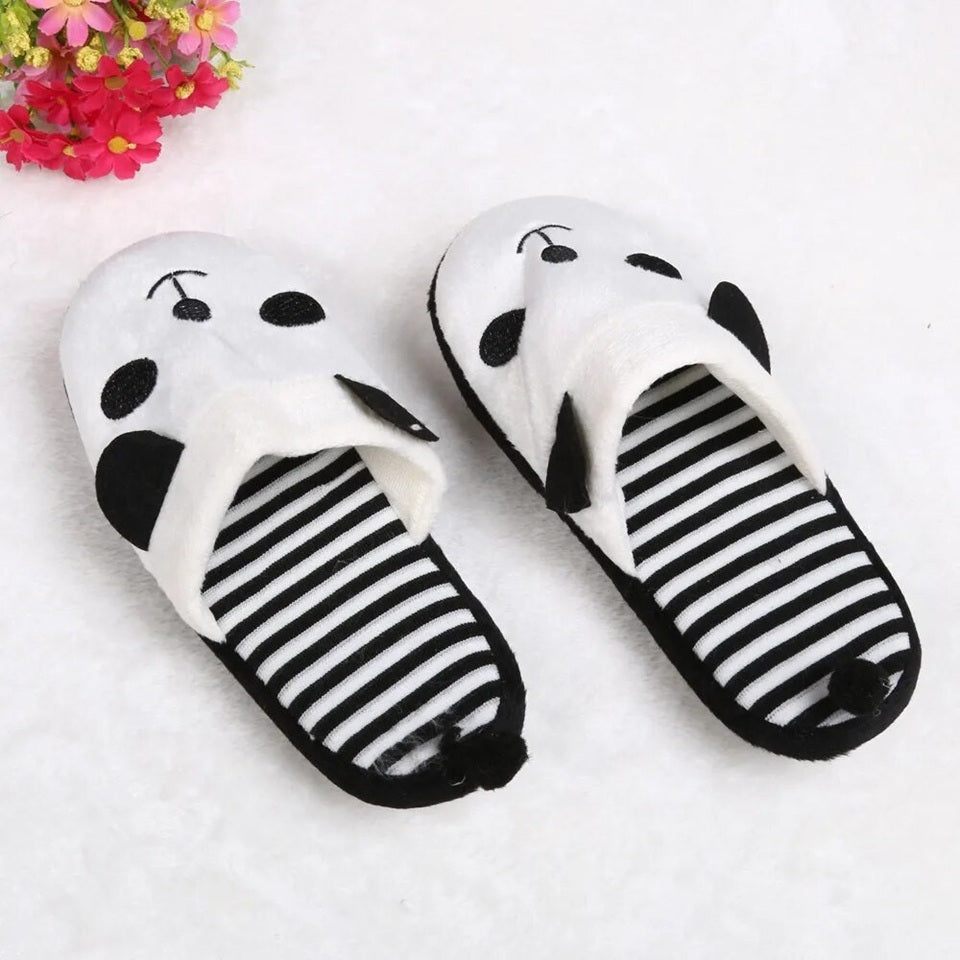 une paire de pantoufles noires et blanches à l'intérieur rayé au design de panda super mignon.