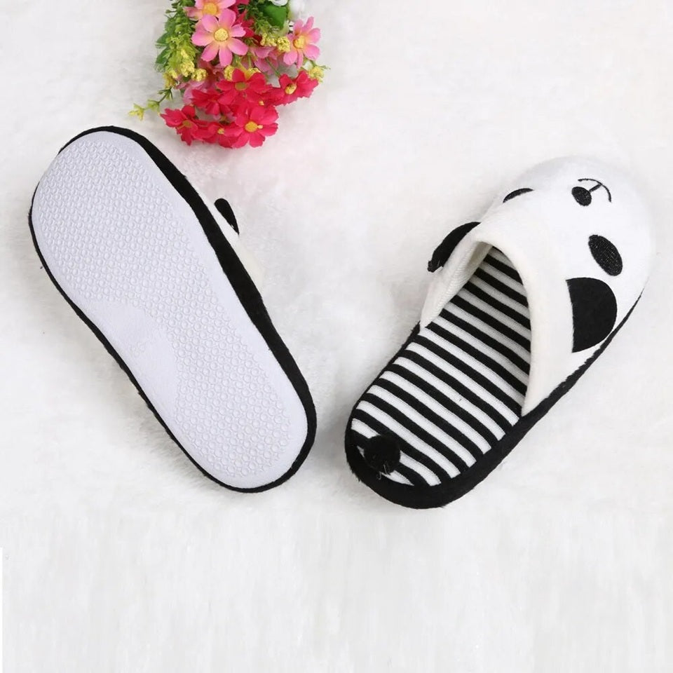 une paire de pantoufles noires et blanches à l'intérieur rayé au design de panda super mignon.