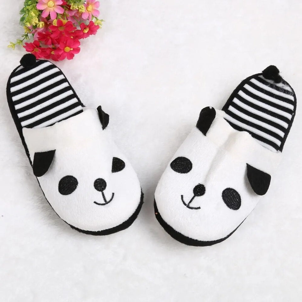 une paire de pantoufles noires et blanches à l'intérieur rayé au design de panda super mignon.