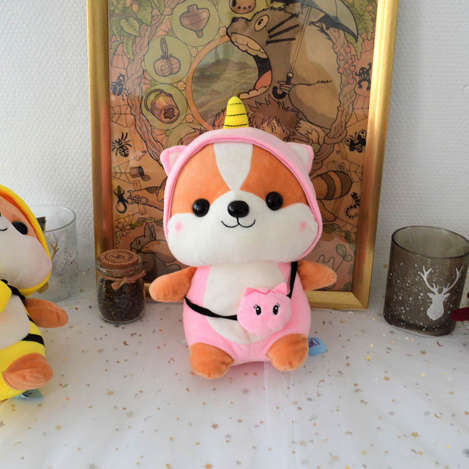 une peluche en forme de chien hyper mignon vêtu d'un kigurumi licorne rose