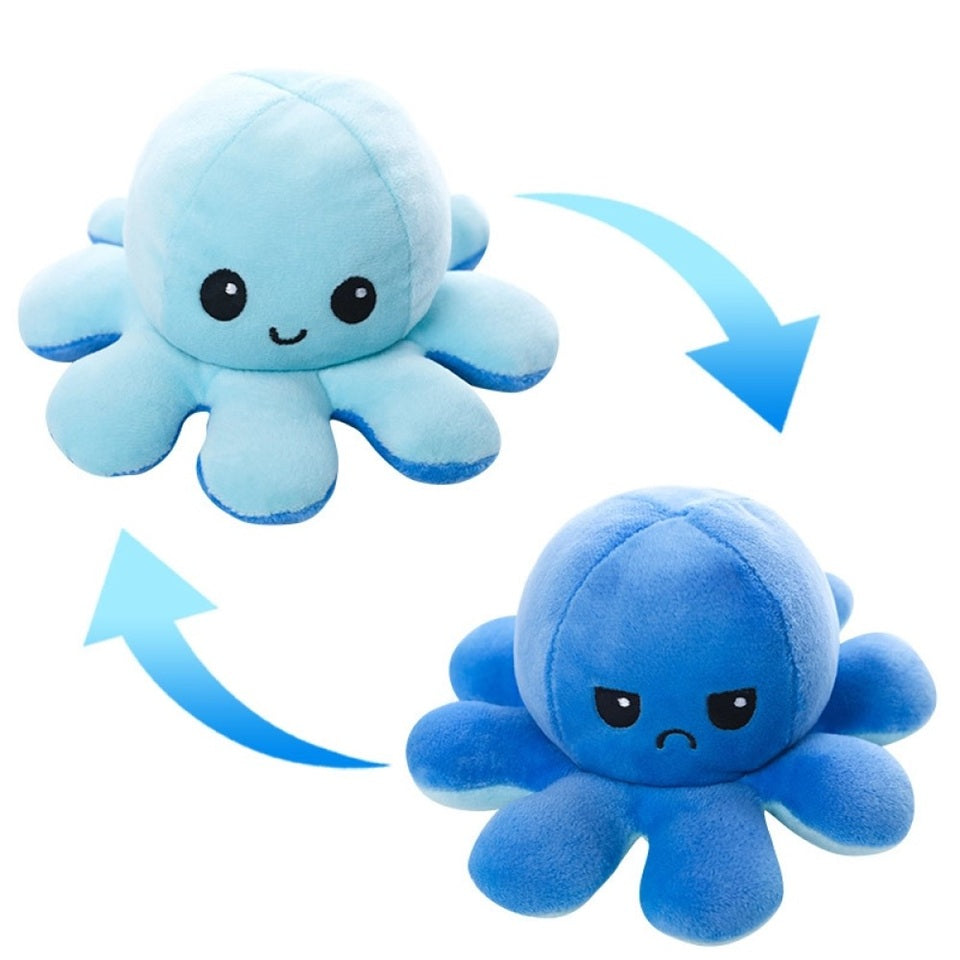 une peluche en forme d'octopus réversible bleue qui exprime deux émotions différentes : d'un côté, l'expression heureuse et joyeuse puis quand on le retourne, une expression boudeuse.