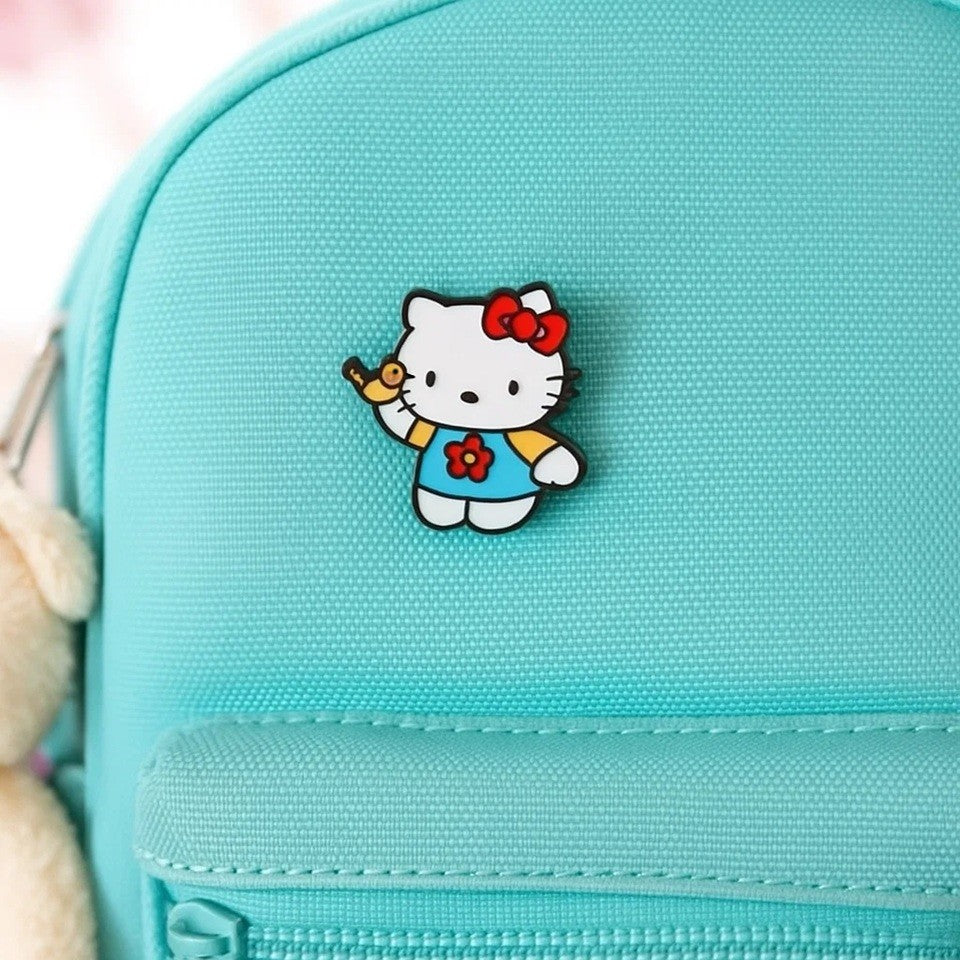un pin's en forme de l'adorable Hello Kitty qui joue avec un petit oiseau jaune.