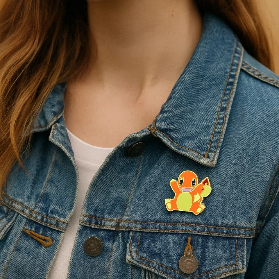 un pin's en forme du charismatique Pokemon Salamèche. On retrouve son design fidèle avec une expression amusante