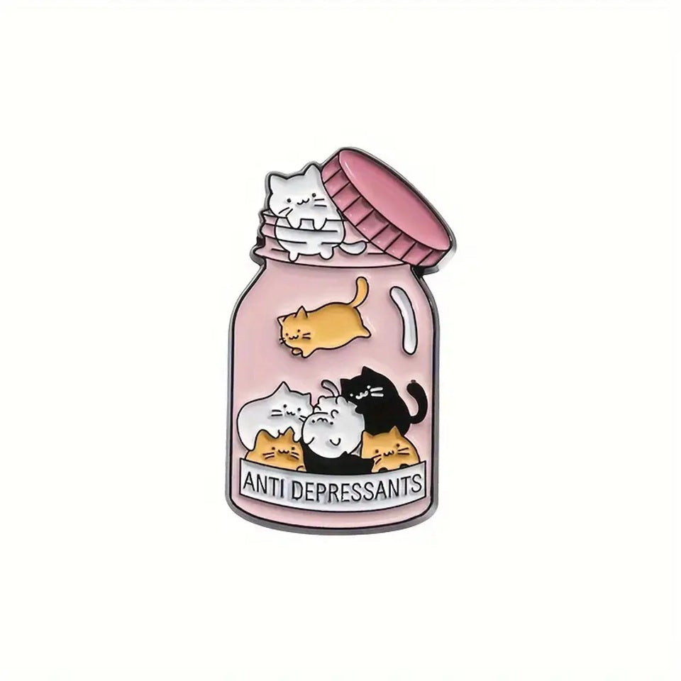 un pin's en forme de bocal dans lequel se trouve plein de petits chats colorés. Sur la boite est inscrit antidepressants, comme si les petits chats étaient un remède contre la morosité
