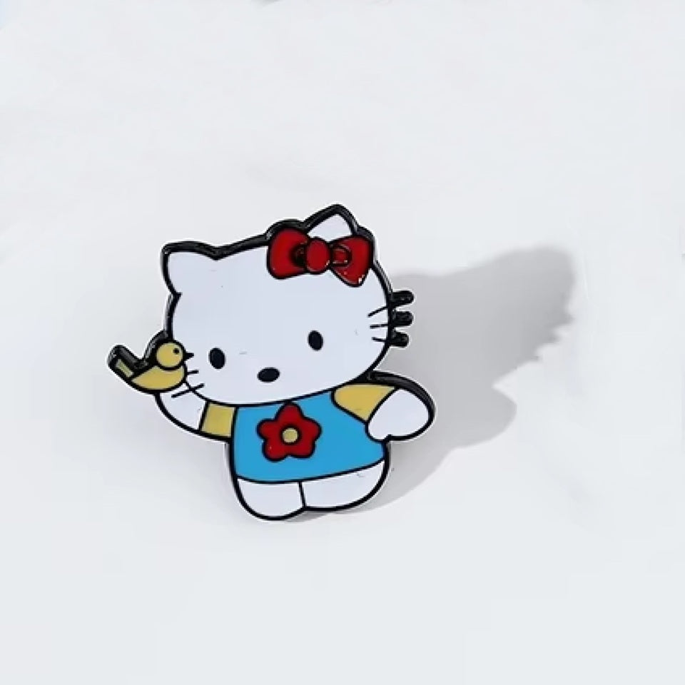 un pin's en forme de l'adorable Hello Kitty qui joue avec un petit oiseau jaune.
