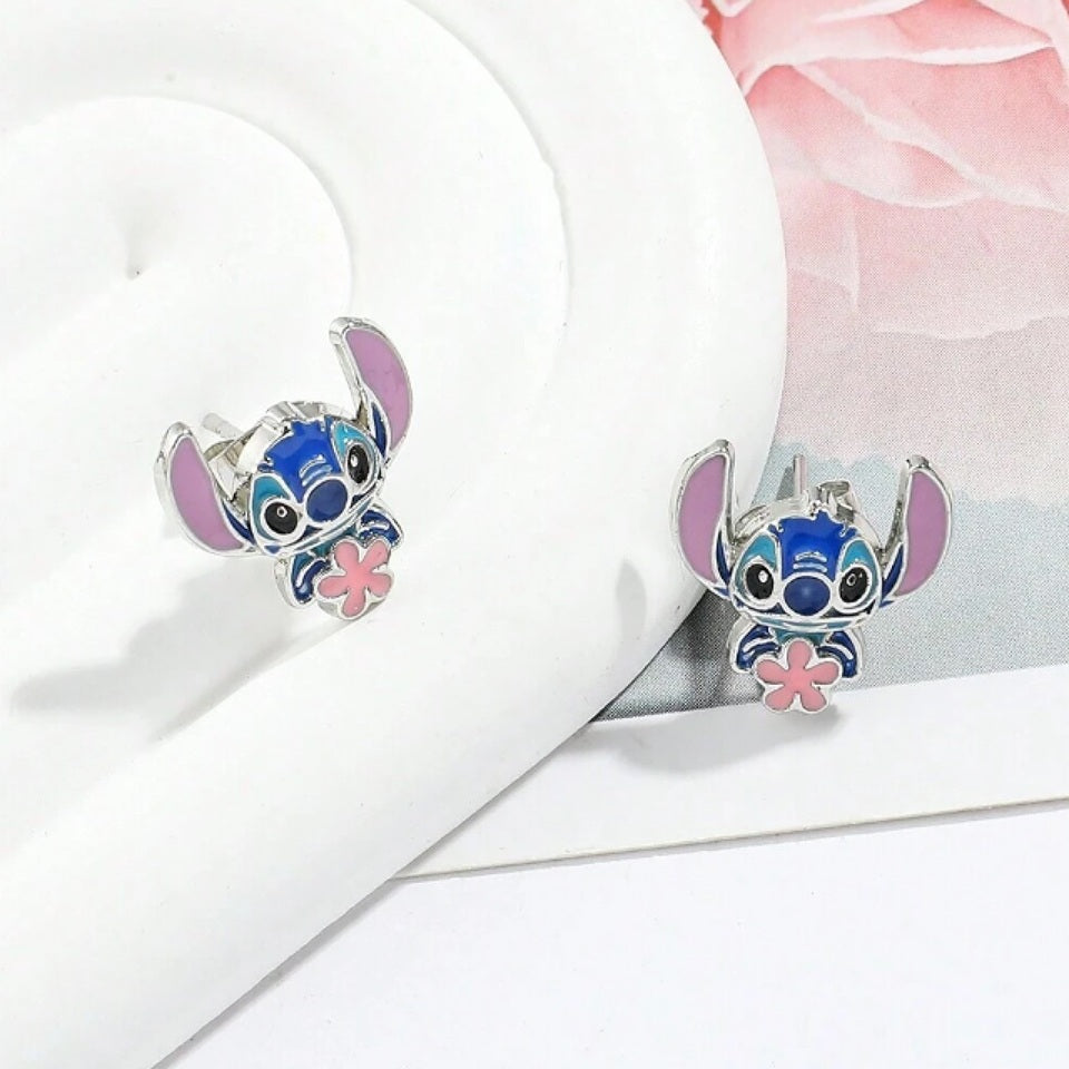 Des puces d'oreilles Stitch qui tient une jolie fleur rose dans ses mains. Fidèle au personnage du dessin animé, il est adorable.