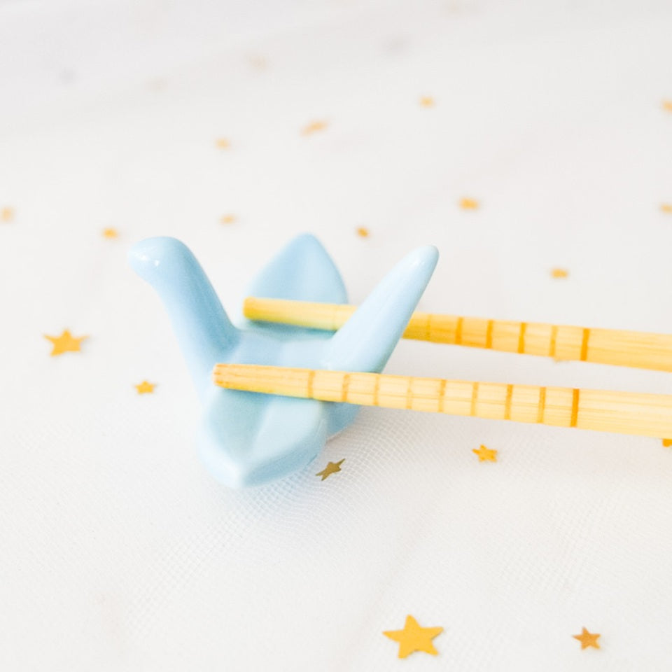 des repose baguettes en forme de grue japonaise colorée : rose, orange, bleu et vert. En céramique, elles sont résistantes et durables et ajoutent une touche authentique du Japon et d'élégance sur votre table.