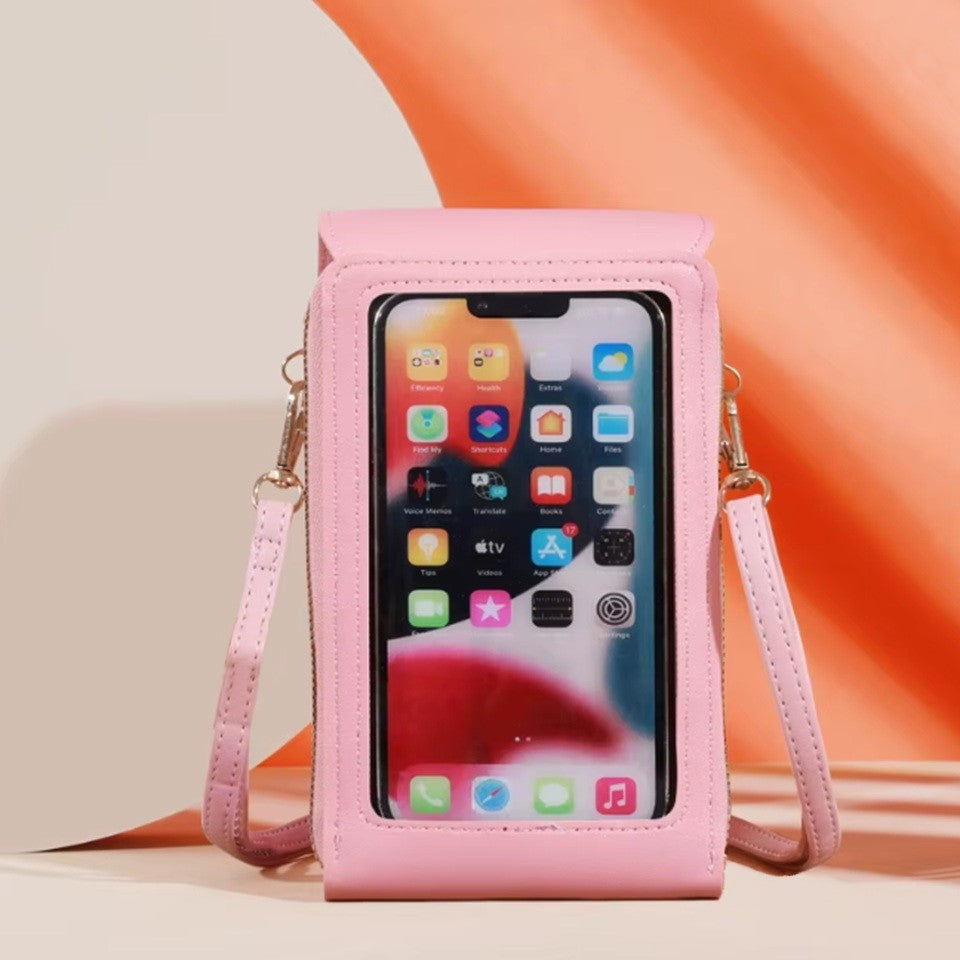 une sacoche pour smartphone est présentée posée dan un décor moderne rose et orangé. On voit le derrière de la sacoche qui est une pochette tactile transparente dans laquelle se trouve un smartphone.