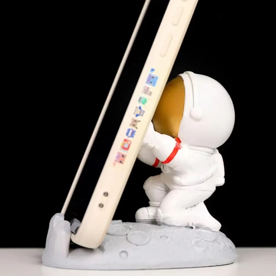 un support pour smartphone en forme d'un astronaute tout mignon. Posez votre smartphone sur ses mains, l'astronaute est en position pour le retenir afin qu'il ne tombe pas. Elément de déco sympa et adorable