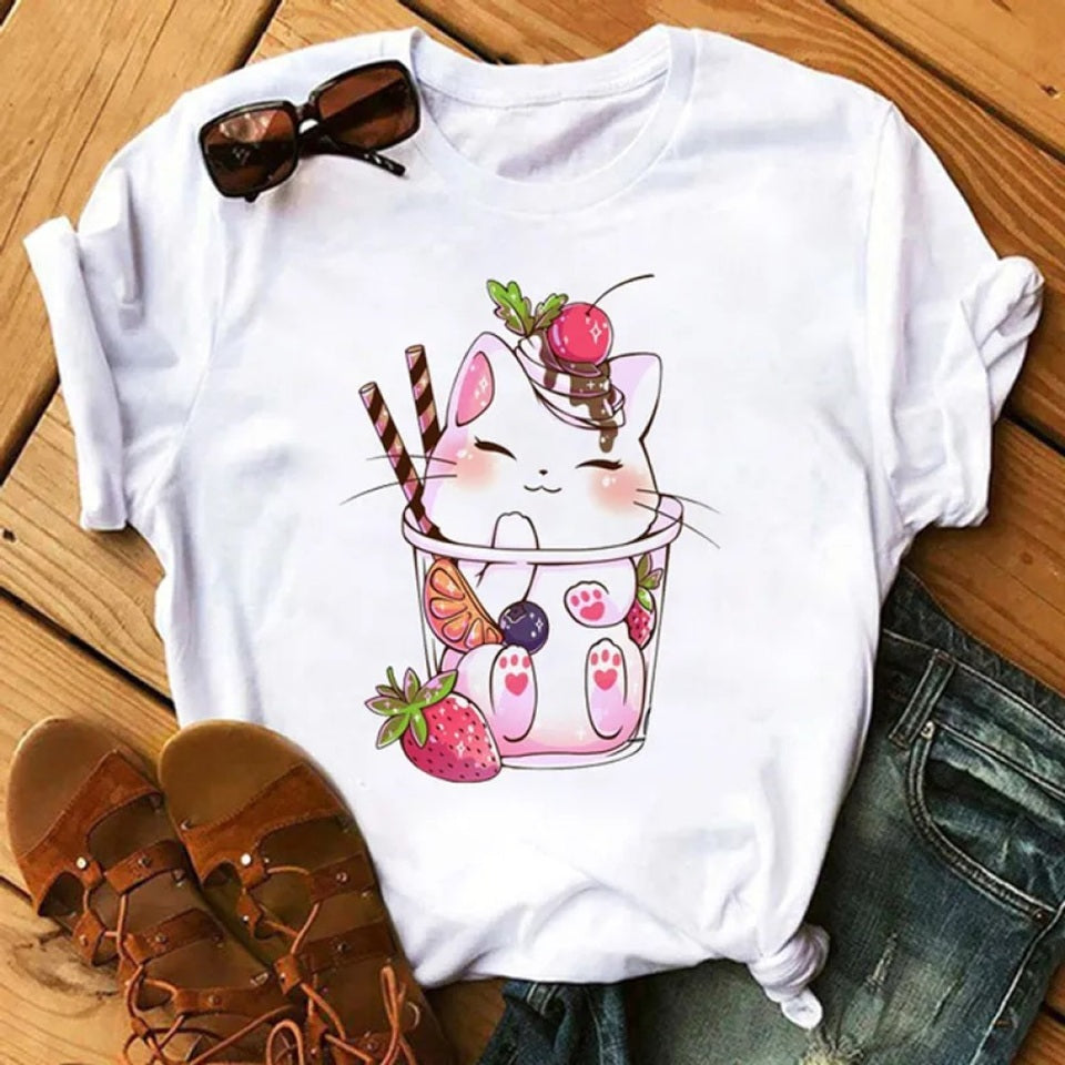 un tee-shirt au design d'un chat dans un verre, il a de la glace sur sa tête ce qui le rend encore plus gourmand. Me design est hyper kawaii et adorable. Parfait pour ajouter une touche mignonne et stylée à ton look