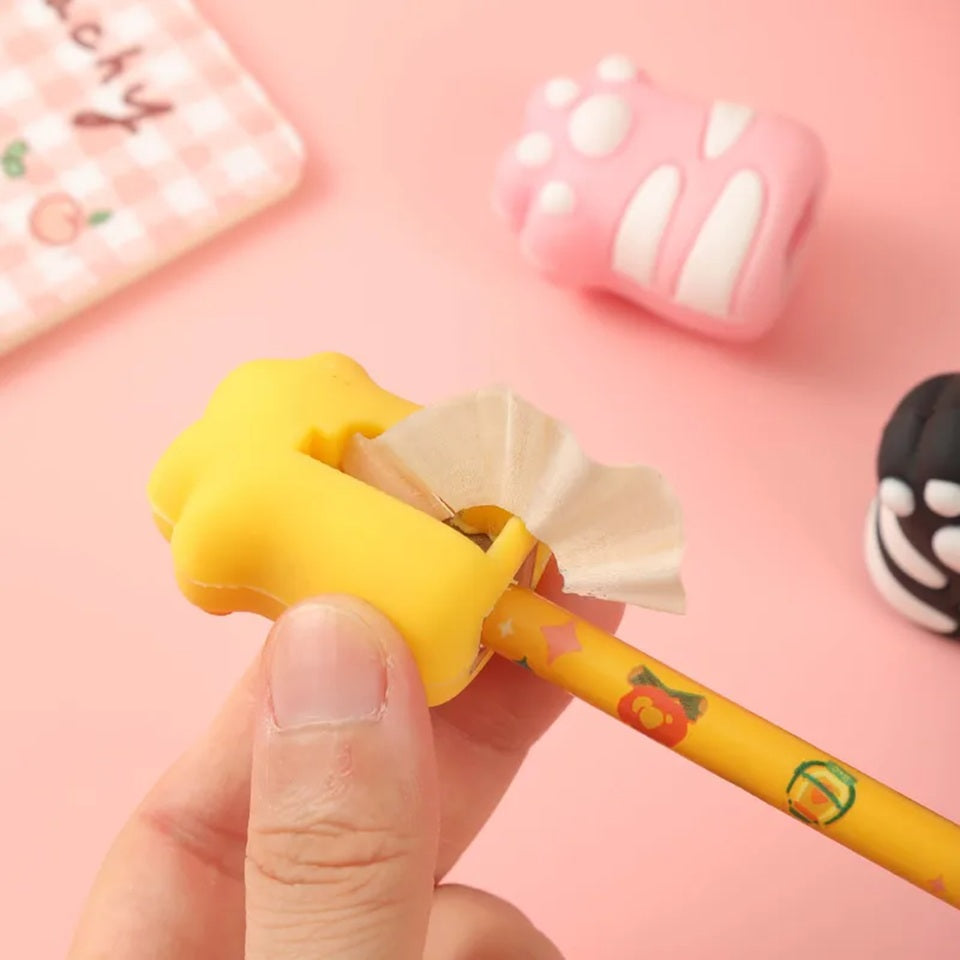 un taille-crayon original et fun en forme de patte de chat coloré : jaune, rose et noir. Hyper mignon, format pratique et originalité.