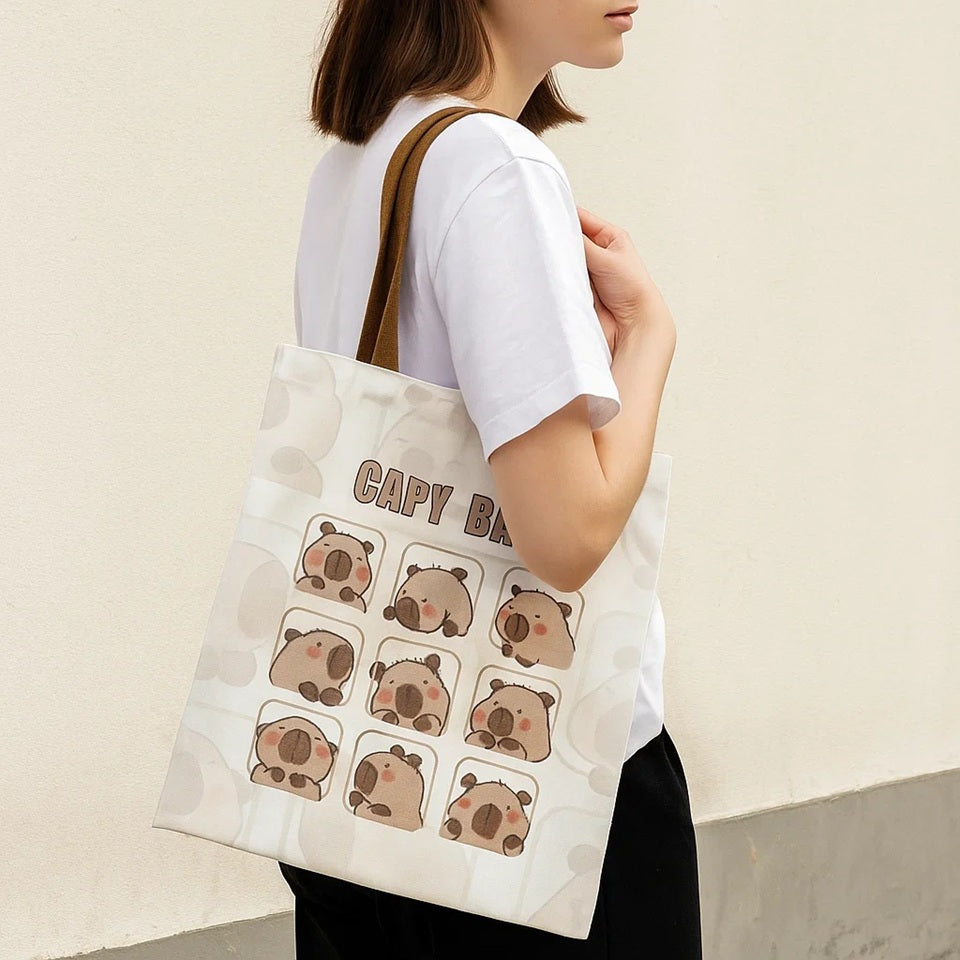 un joli tote bag inspiré des capybara. Illustré de plusieurs cases dans lesquelles se trouve un capybara différent à chaque fois, il est adorable ! En polyester, il est résistant et durable.