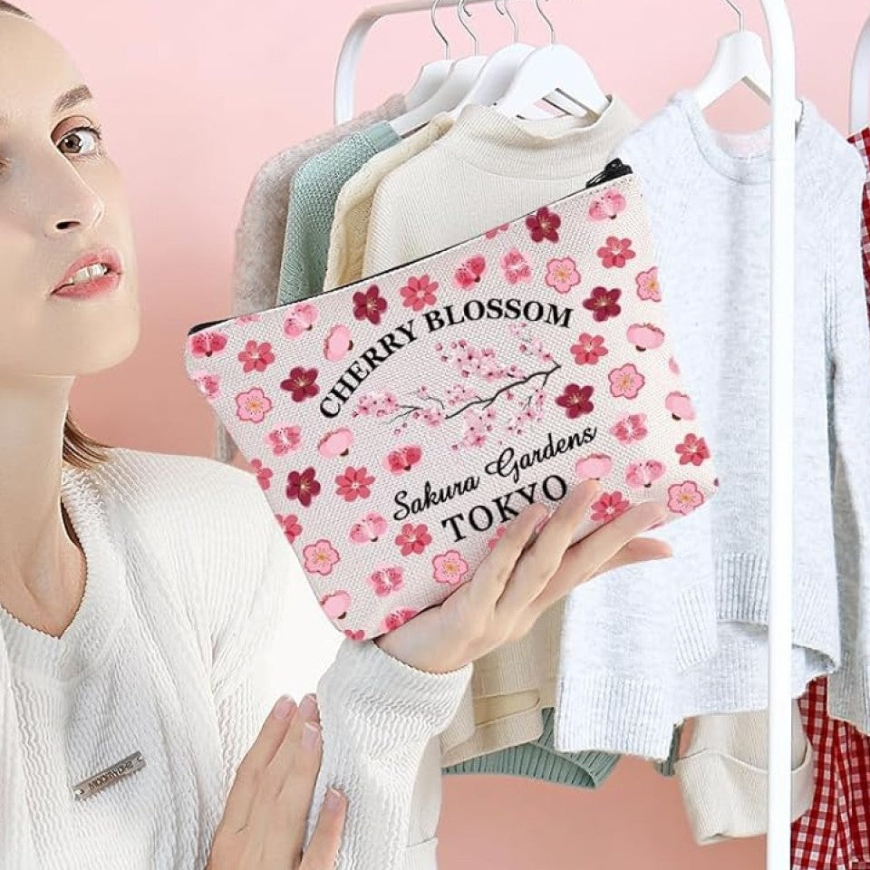 une magnifique trousse de toilette en polyester ornée de motifs de fleurs de sakura roses. Le motif rappelle les sakura en fleurs dans les jardins de Tokyo.