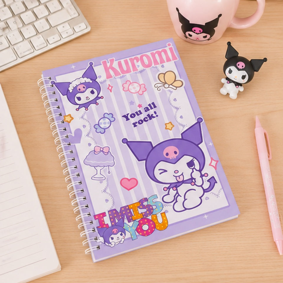 Cahier à spirales Kuromi kawaii violet posé sur un bureau avec accessoires assortis ✨ Carnet adorable inspiré de l’univers Sanrio avec illustrations de Kuromi, bonbons et détails pastel, parfait pour écrire ses notes, son journal ou organiser ses idées créatives. Ambiance douce et cosy avec tasse, figurine Kuromi et papeterie kawaii.