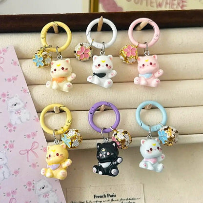 un porte-clés en forme d'un chat kawaii coloré tout mignon, il est accompagné de son grelot en forme de sakura.