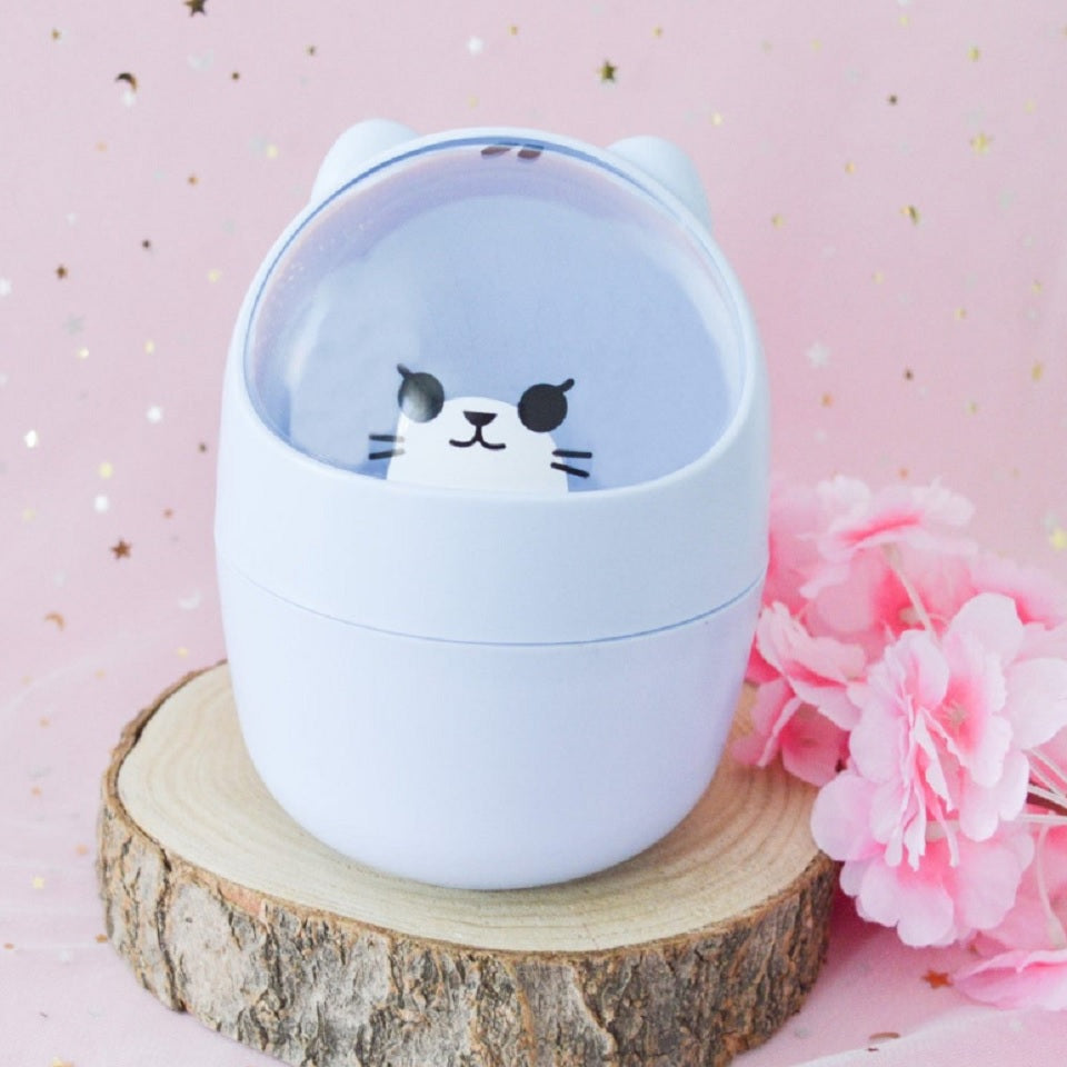 une adorable poubelle de bureau de couleur bleu en forme de chat hyper kawaii. Il a une douce expression et des petites oreilles.
