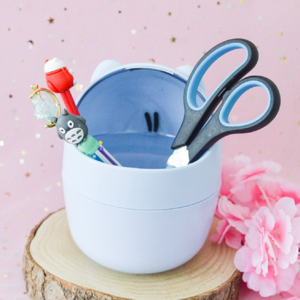 une adorable poubelle de bureau de couleur bleu en forme de chat hyper kawaii. Il a une douce expression et des petites oreilles.