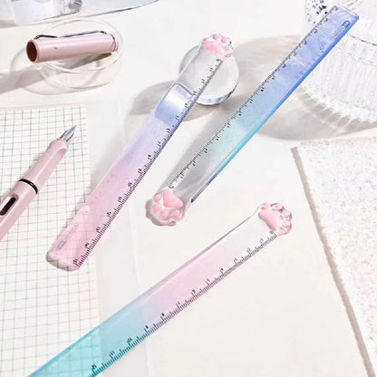 une règle pailletée en forme de patte de chat toute mignonne avec ses coussinets roses. graduée jusqu'à 15 cm, elle est trop kawaii avec son dégradé de couleur pastel