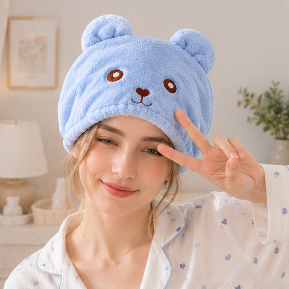 Personne portant une serviette pour cheveux kawaii bleue en forme d’ourson ultra douce et moelleuse ✨ Serviette adorable avec petites oreilles et visage brodé, parfaite pour sécher les cheveux après la douche tout en ajoutant une touche cute et cosy à sa routine beauté. Ambiance cocooning lumineuse avec pyjama pastel et décoration douce.

