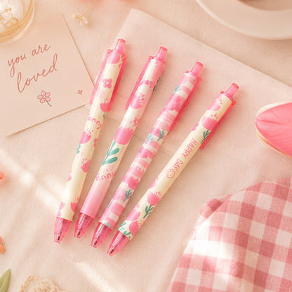 Quatre stylos kawaii roses à motifs floraux et tulipes pastel posés sur un tissu beige avec décoration douce et romantique, ambiance papeterie coréenne mignonne et printanière.