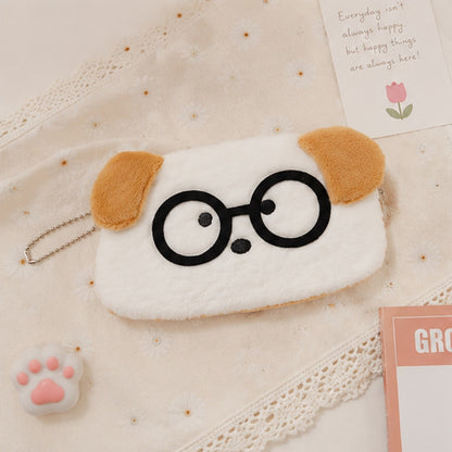 une adorable trousse toute douce en forme de chien blanc aux oreilles brunes. Il porte des lunettes noires rigolotes.