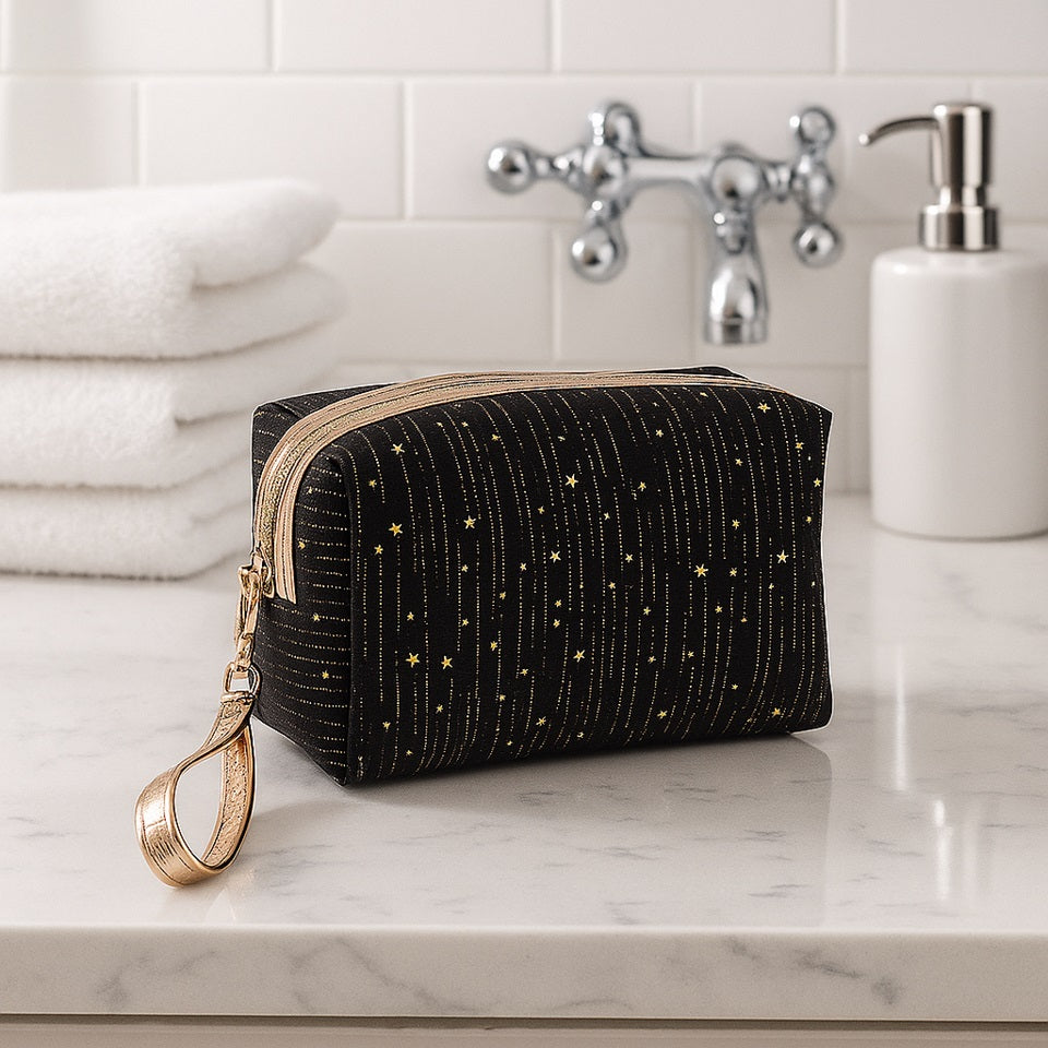une trousse en velours noirs toute douce ornée de pluie d'étoiles dorées. LA fermeture éclair est dorée et elle possède une lanière de transport dorée.