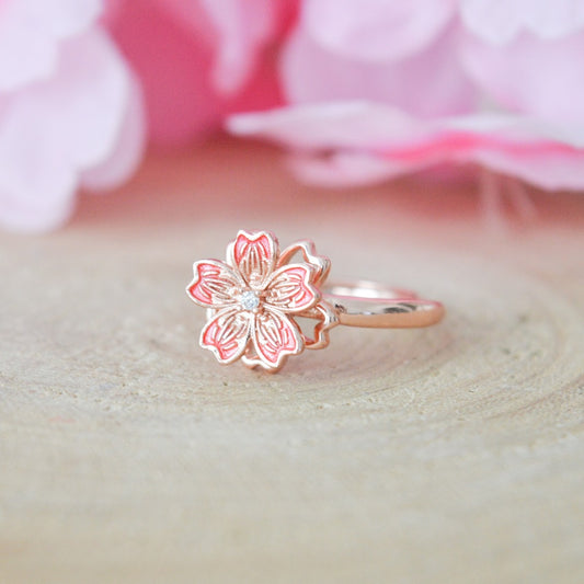 une jolie bague rotative en coloris rose gold en forme de fleur de sakura. Elégance et raffinement se combinent dans ce bijou aux effet anti stress et apaisant.