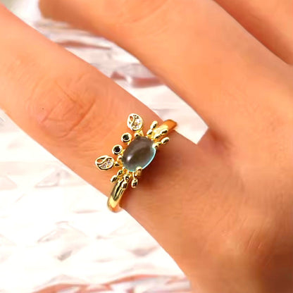 une superbe bague dorée réglable en forme de crabe qui lève les pinces. Son corps est un joli strass bleu transparent qui rappelle la mer. Ses pinces ont des strass.