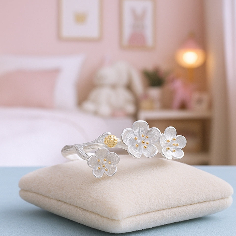 une bague en argent sterling 925 de taille réglable au design délicat de fleurs de pruniers. Les pistils sont dorés.