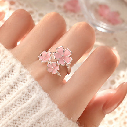 une jolie bague argentée réglable en forme de trois fleurs de sakura roses. Jolie design romantique et floral