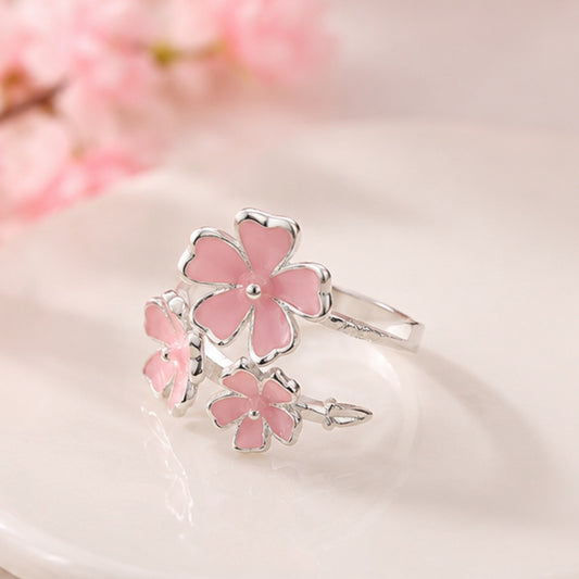 une jolie bague argentée réglable en forme de trois fleurs de sakura roses. Jolie design romantique et floral