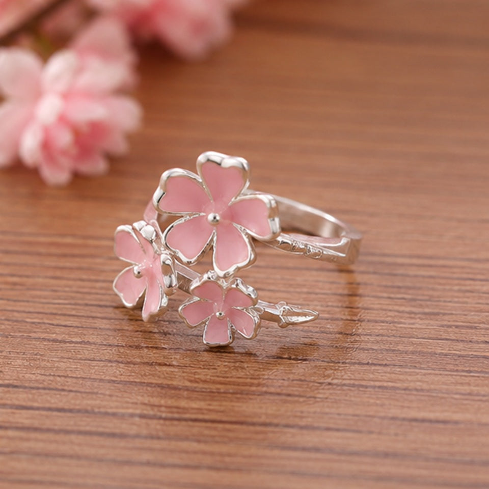 une jolie bague argentée réglable en forme de trois fleurs de sakura roses. Jolie design romantique et floral