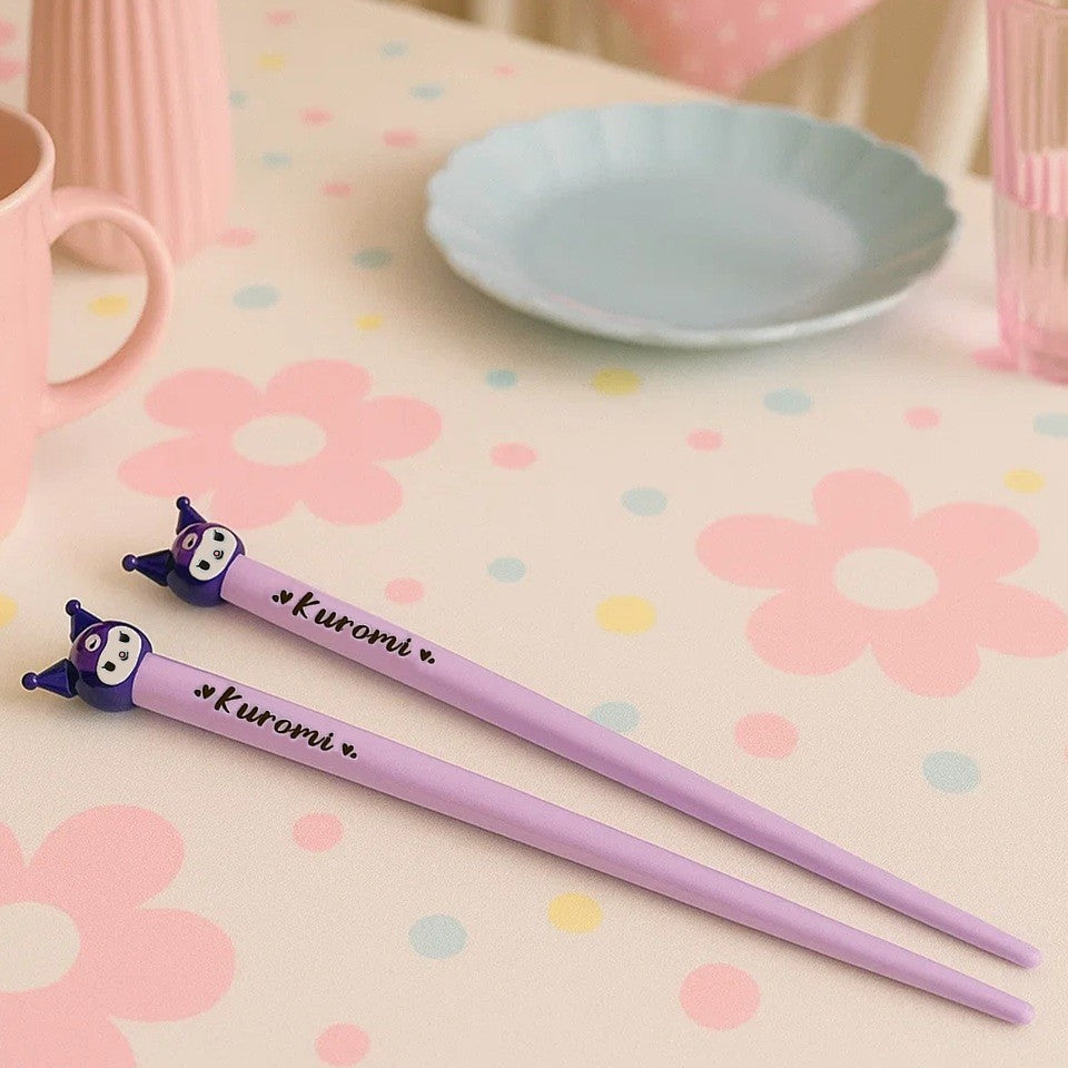 une paire de baguettes violettes inspirés de Kuromi. On la retrouve au bout de ces baguettes. Elles apportent une touche fun et amusante à tous vos repas.