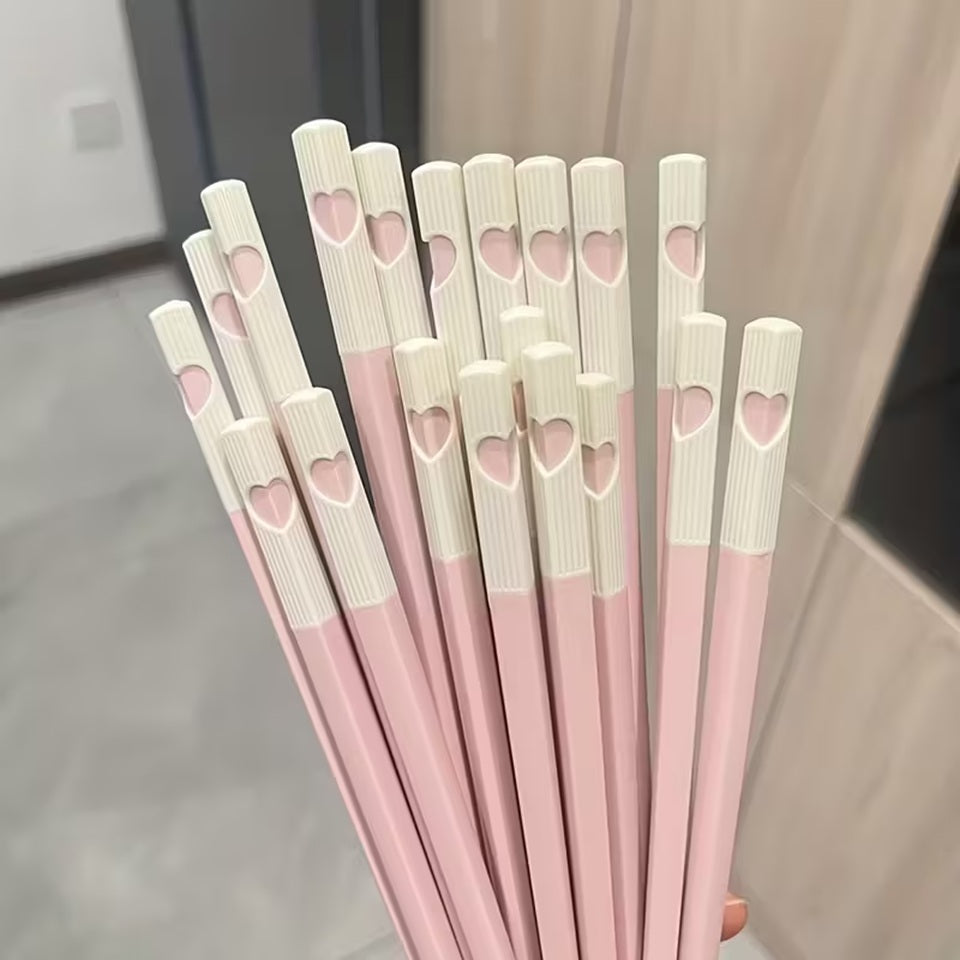 une jolie paire de baguettes roses et blanches. Au bout des baguettes, se trouve un petit coeur qui se reforme quand on regroupe les deux baguettes. C'est trop mignon !