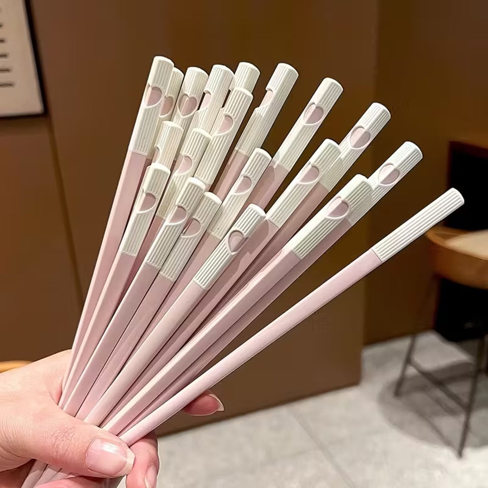 une jolie paire de baguettes roses et blanches. Au bout des baguettes, se trouve un petit coeur qui se reforme quand on regroupe les deux baguettes. C'est trop mignon !