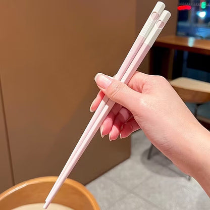 une jolie paire de baguettes roses et blanches. Au bout des baguettes, se trouve un petit coeur qui se reforme quand on regroupe les deux baguettes. C'est trop mignon !