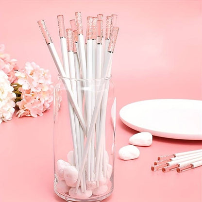 une paire de baguettes japonaises blanches délicatement décorées au bout de fleurs de sakura. Au bout, elles sont transparentes et joliment colorées de rose. Idéales pour une table élégante et raffinée.
