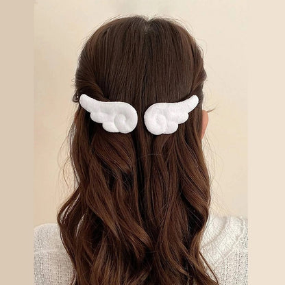 une paire de barrettes à cheveux en forme d'ailes d'ange blanches ou roses. Pour un look kawaii et romantique elles sont parfaites. En matière peluchée, elles sont toutes douces.