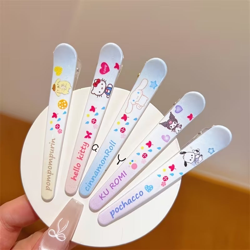 des barrettes à cheveux inspirées des personnages Sanrio : kuromi, hello kitty, cinnamoroll, pompompurin et pochacco dans des tons de couleurs pastels douces.