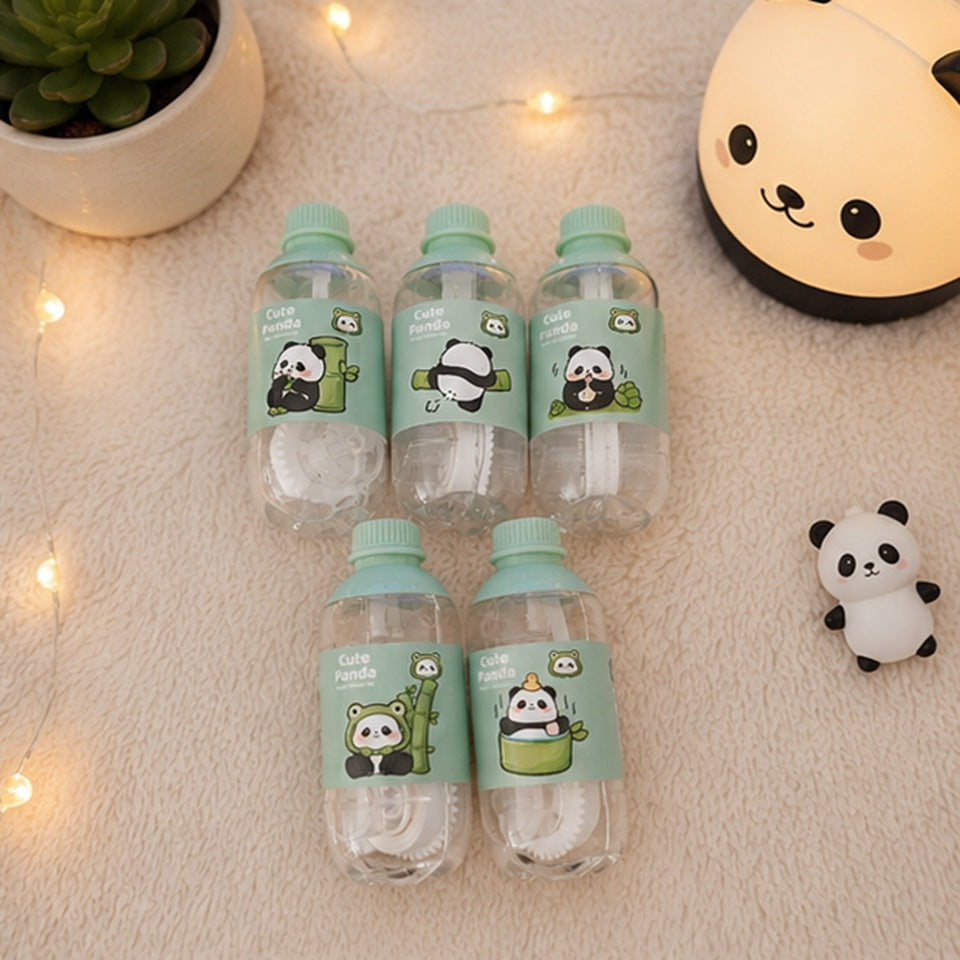 Lot de correcteurs à ruban kawaii en forme de petite bouteille avec motifs panda, présentés dans un joli décor pastel  entouré de divers accessoires de décoration panda. Correcteurs décoratifs et pratiques pour l'école, le bureau ou le bullet journal.