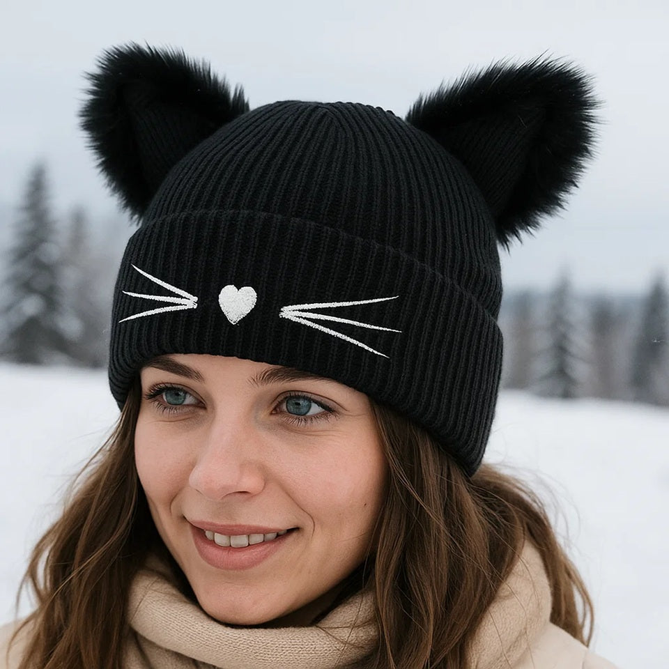 un adorable bonnet noir doté d'oreilles de chat toutes fluffy et douces. Une petite truffe en forme de coeur et des moustaches sont brodées sur le revers du bonnet. Il est très doux et confortable à porter.