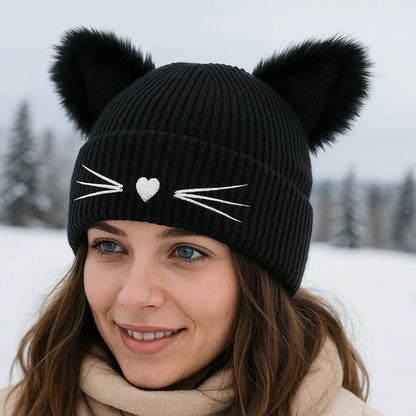 un adorable bonnet noir doté d'oreilles de chat toutes fluffy et douces. Une petite truffe en forme de coeur et des moustaches sont brodées sur le revers du bonnet. Il est très doux et confortable à porter.
