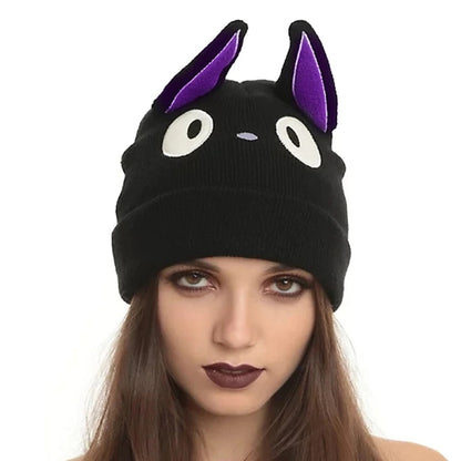 un bonnet représentant le chat noir Jiji dans Kiki la petite sorcière. Il possède deux grandes oreilles violettes