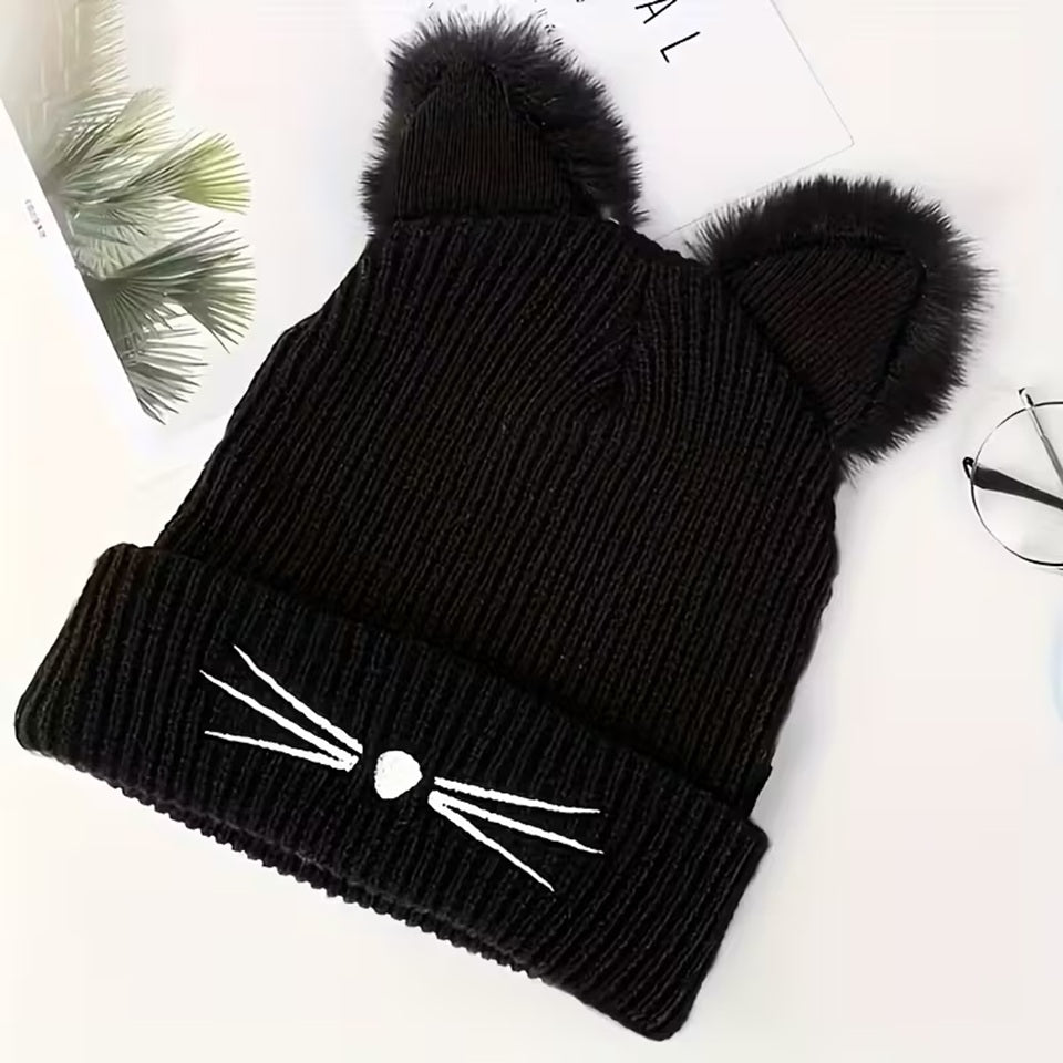 un adorable bonnet noir doté d'oreilles de chat toutes fluffy et douces. Une petite truffe en forme de coeur et des moustaches sont brodées sur le revers du bonnet. Il est très doux et confortable à porter.